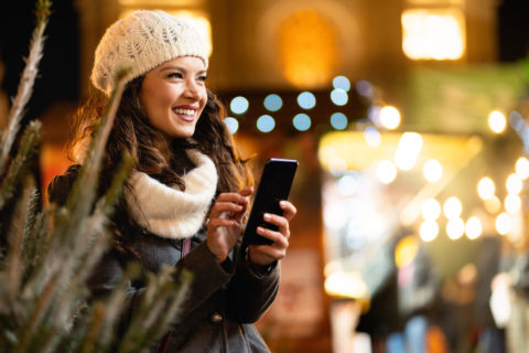 Woman on phone in winter market at night