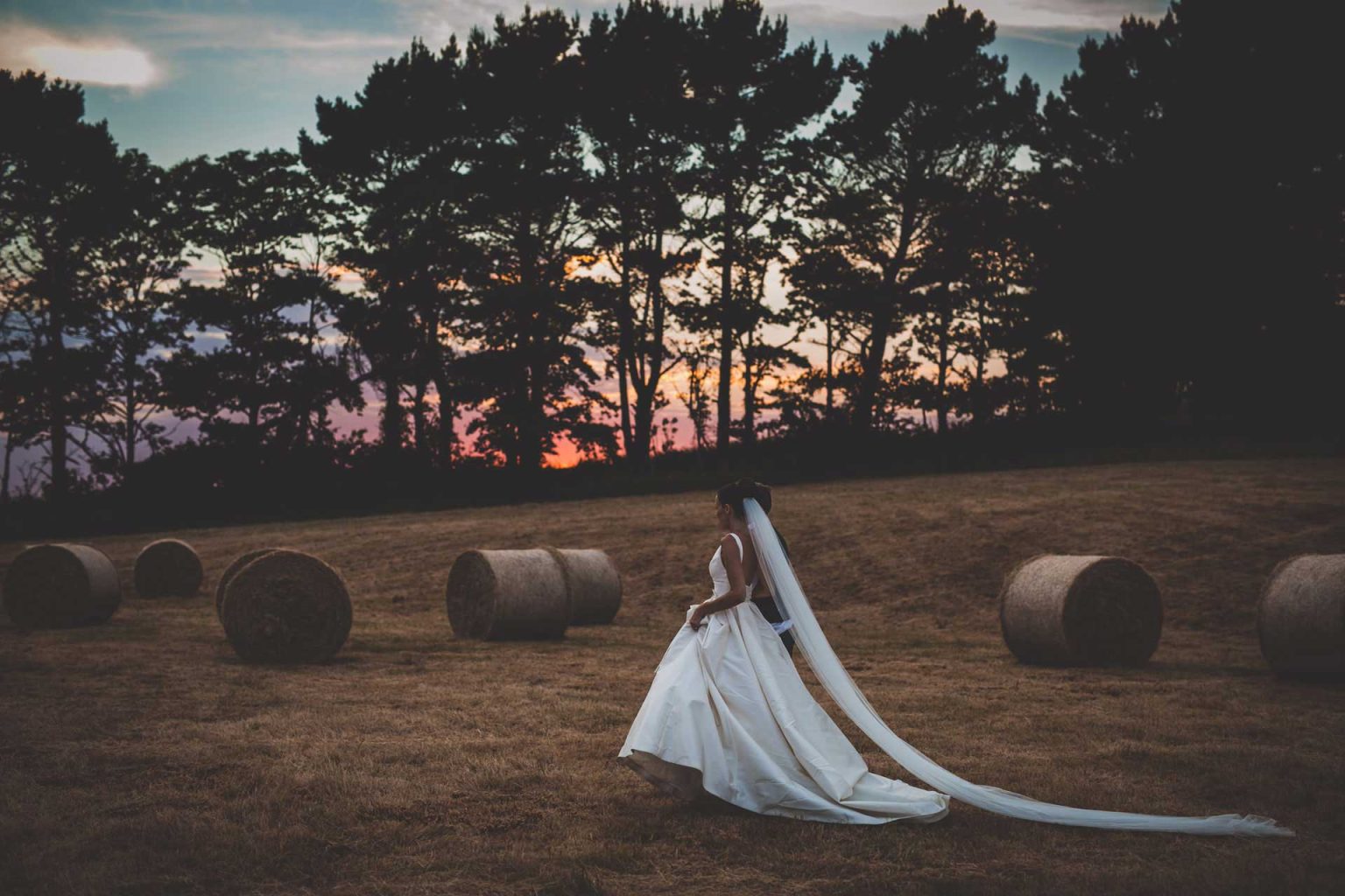 Wedding sunset photographers hay bail feild classic wedding dress